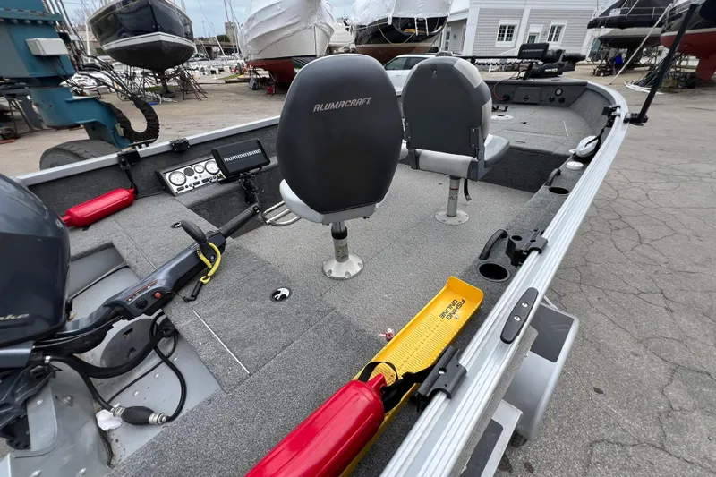 Slide: The Image of 2014 Alumacraft Competitor 165 Tiller boat interior with seats and fishing equipment. - 10