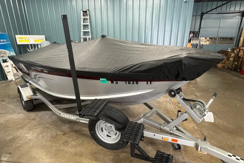 Slide: The Image of 2014 Alumacraft Competitor 165 Tiller boat on trailer, covered, in a garage setting. - 25