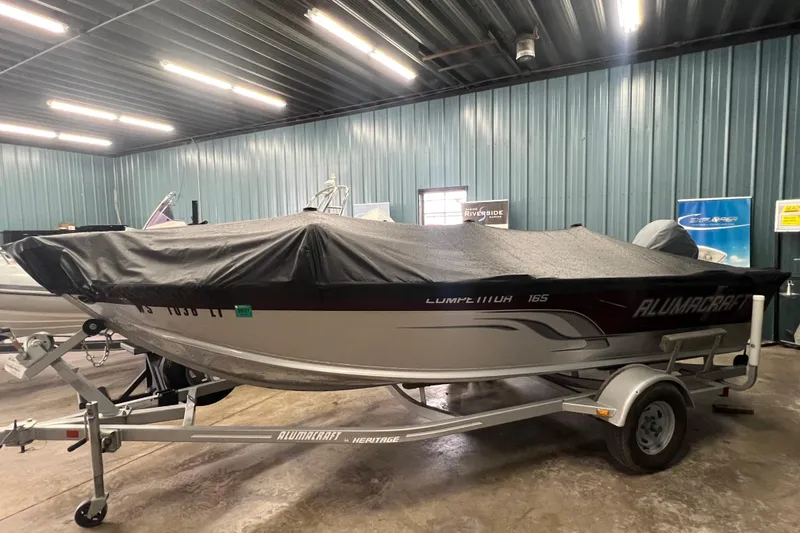 Slide: The Image of 2014 Alumacraft Competitor 165 Tiller boat with cover in a storage facility. - 26