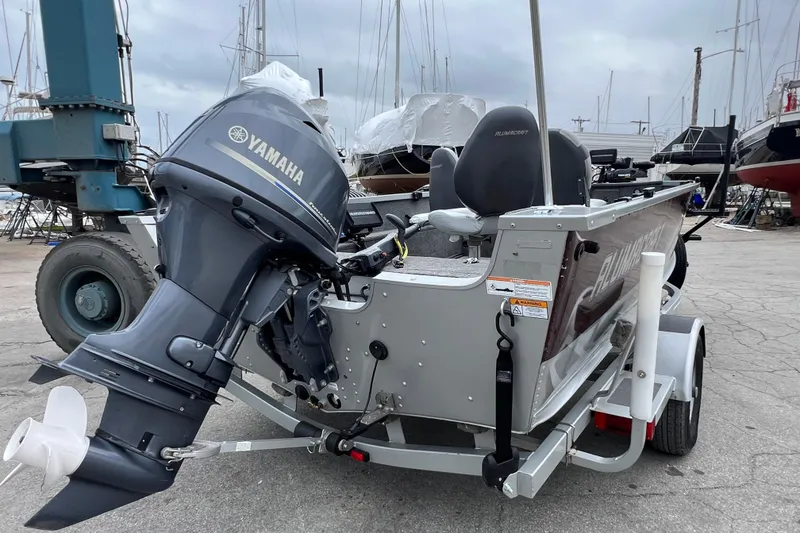 Slide: The Image of 2014 Alumacraft Competitor 165 Tiller boat with Yamaha outboard motor in a marina setting. - 5