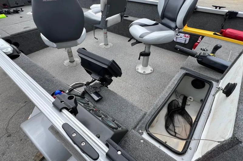 Slide: The Image of 2014 Alumacraft Competitor 165 Tiller interior with seats, storage, and fishing equipment. - 8