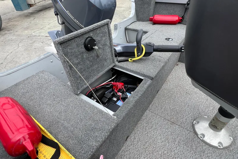 Slide: The Image of 2014 Alumacraft Competitor 165 Tiller boat interior with open storage compartment and safety equipment. - 9