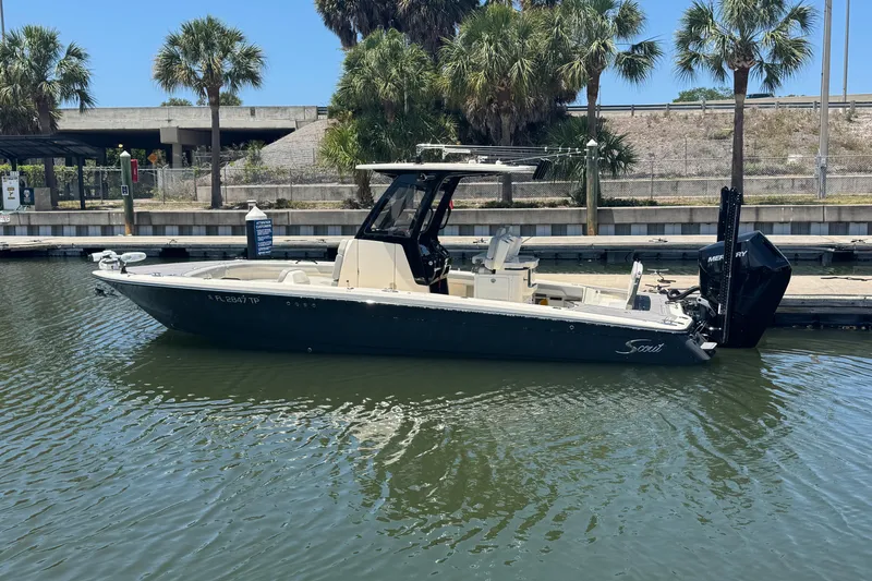 The Image of 2024 Scout 281 XSS boat docked in a marina with palm trees in the background. - 0