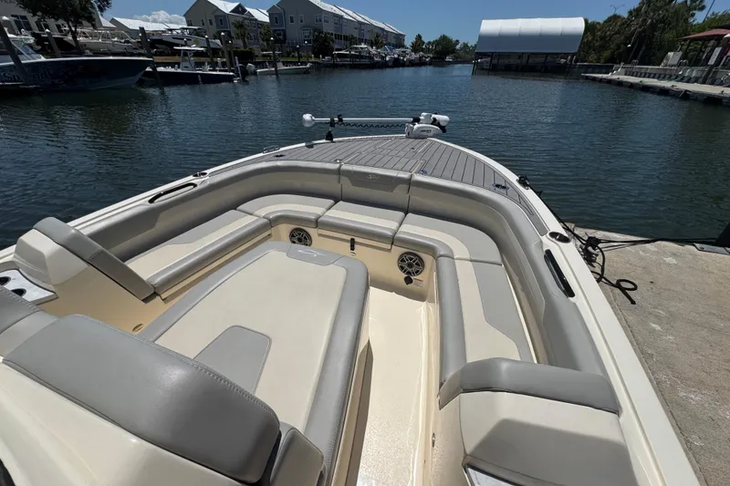 Slide: The Image of 2024 Scout 281 XSS boat interior with spacious seating at a marina dock. - 10