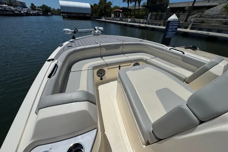 Slide: The Image of 2024 Scout 281 XSS boat interior with spacious seating at a marina. - 11