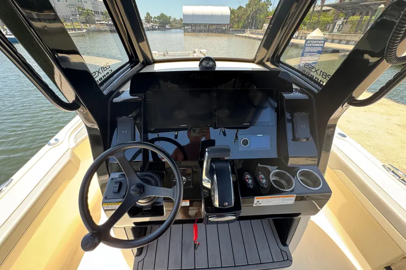 Slide: The Image of 2024 Scout 281 XSS boat dashboard with steering wheel and electronic controls. - 13