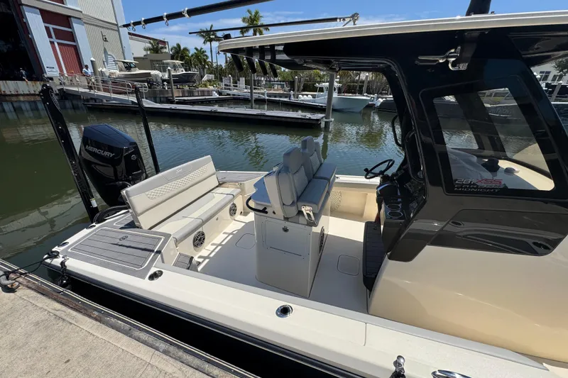 Slide: The Image of 2024 Scout 281 XSS boat interior with seating and Mercury engine at a marina. - 19
