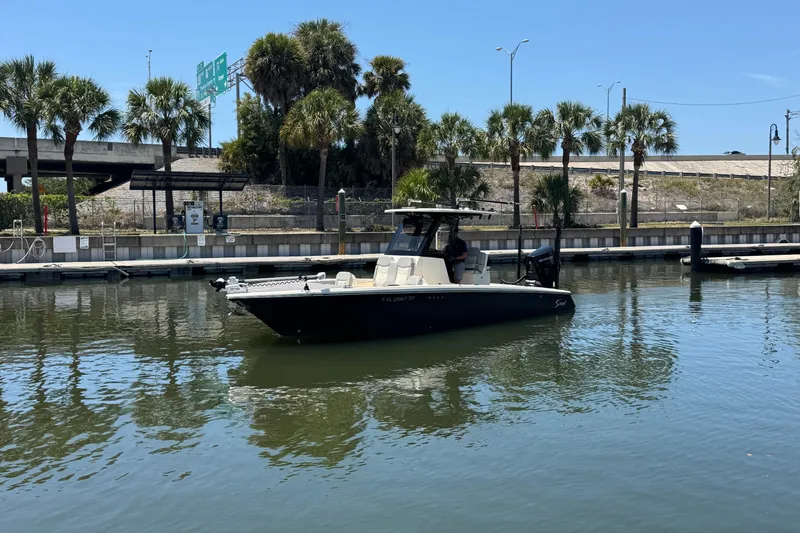 Slide: The Image of 2024 Scout 281 XSS boat docked in a marina with palm trees in the background. - 3