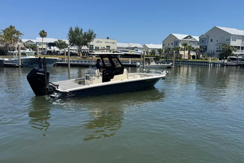 Slide: The Image of 2024 Scout 281 XSS boat docked in a marina with waterfront homes. - 4