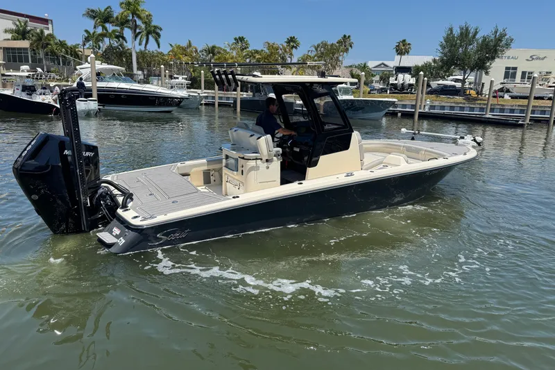 Slide: The Image of 2024 Scout 281 XSS boat cruising in a marina, surrounded by other boats and palm trees. - 5