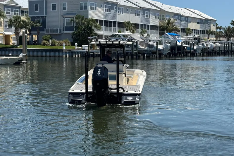 Slide: The Image of 2024 Scout 281 XSS boat cruising near waterfront homes and docks. - 7