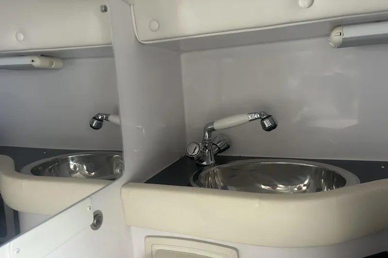 Slide: The Image of 2006 Donzi 43 ZR boat interior sink with chrome faucet and mirror reflection. - 16