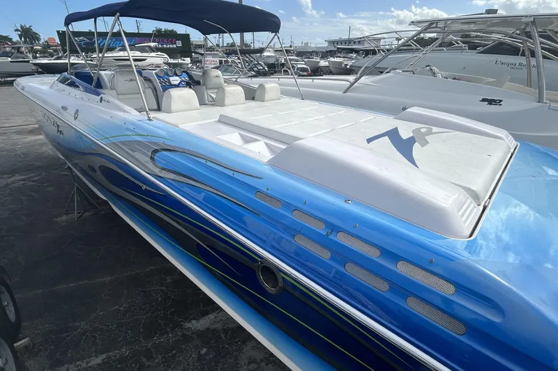 Slide: The Image of 2006 Donzi 43 ZR speedboat with blue and white design, docked at a marina. - 2
