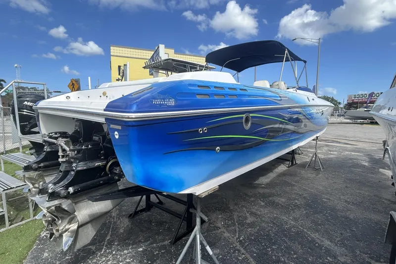 Slide: The Image of 2006 Donzi 43 ZR speedboat with vibrant blue design, parked outdoors under a clear sky. - 21