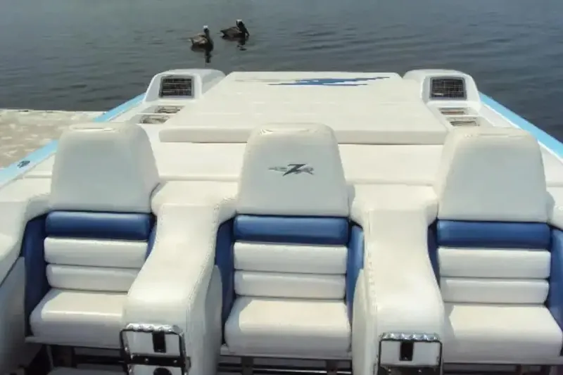 Slide: The Image of 2006 Donzi 43 ZR boat interior with white and blue seating on calm water. - 4