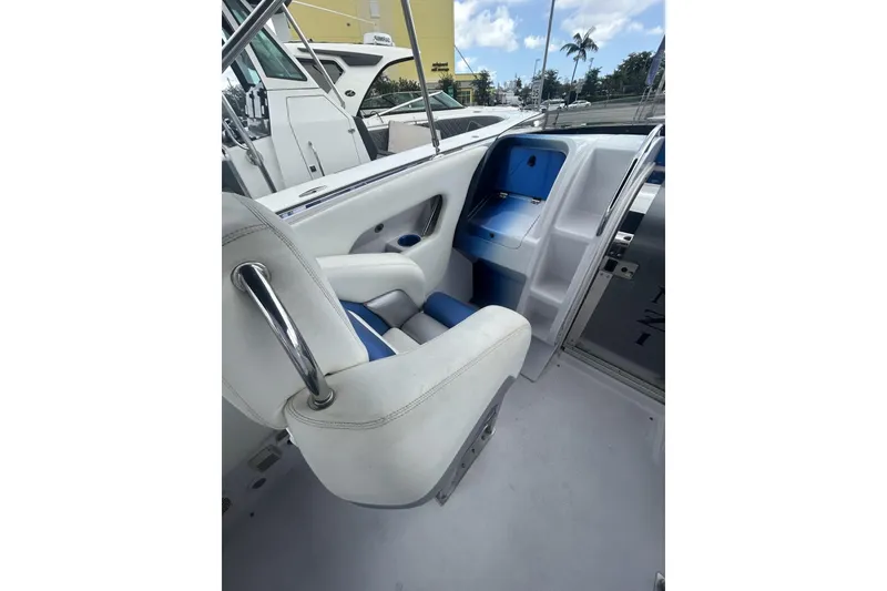 Slide: The Image of 2006 Donzi 43 ZR boat interior with white and blue seating, docked under a sunny sky. - 7