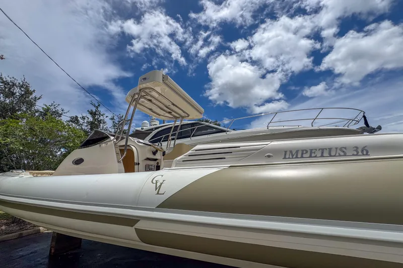 Slide: The Image of 2023 Tender Impertus 36 boat under a vibrant blue sky with clouds. - 36