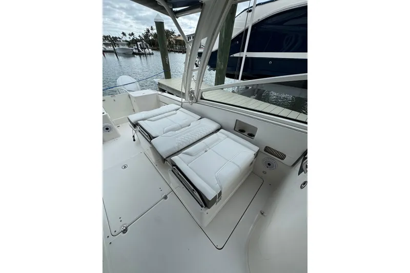 Slide: The Image of 2022 World Cat 325 DC boat with white cushioned seating, docked at marina. - 11