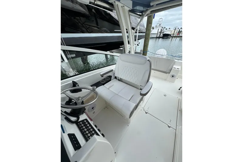 Slide: The Image of 2022 World Cat 325 DC boat interior with steering wheel and seating area. - 12