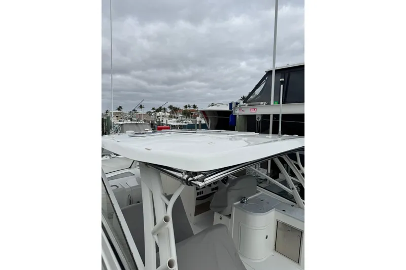 Slide: The Image of 2022 World Cat 325 DC boat docked, showcasing sleek design and spacious deck under cloudy skies. - 15