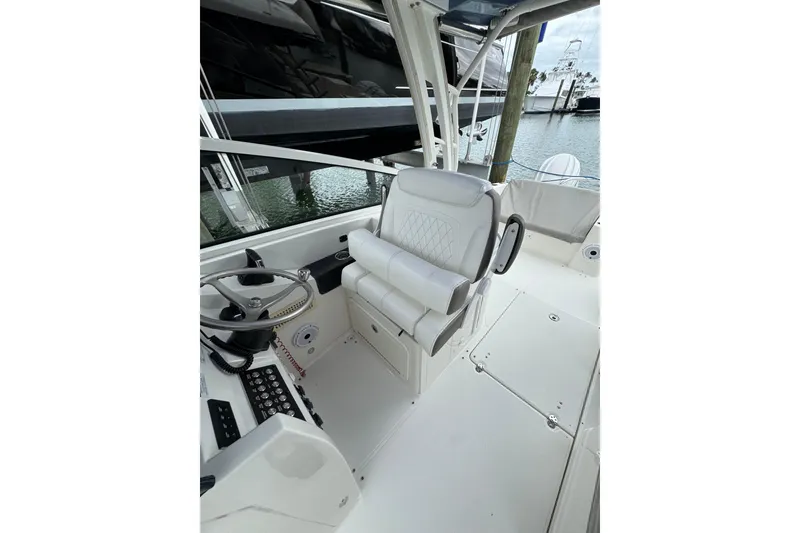 Slide: The Image of 2022 World Cat 325 DC boat on stands under clear blue sky. - 2