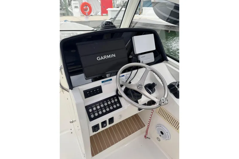 Slide: The Image of Cockpit of 2022 World Cat 325 DC with Garmin navigation system and steering wheel. - 20