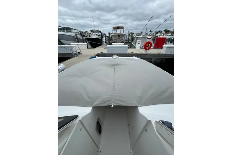 Slide: The Image of 2022 World Cat 325 DC boat docked at marina under cloudy skies. - 25