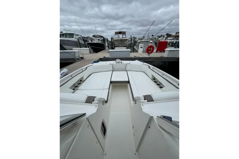 Slide: The Image of 2022 World Cat 325 DC boat interior at marina, showcasing spacious seating and sleek design. - 26