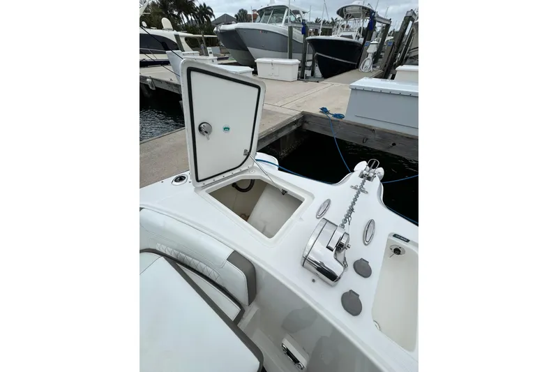 Slide: The Image of 2022 World Cat 325 DC boat at dock with open storage compartment. - 30