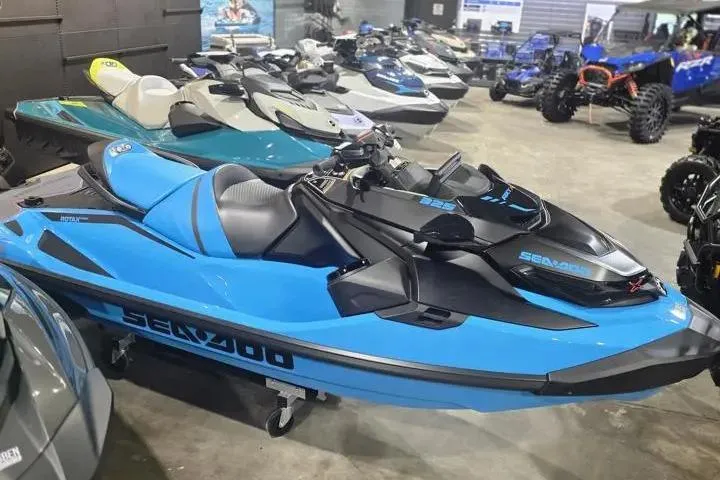 Slide: The Image of 2026 Sea-Doo RXT-X 325 jet ski in showroom, vibrant blue and black design. - 11