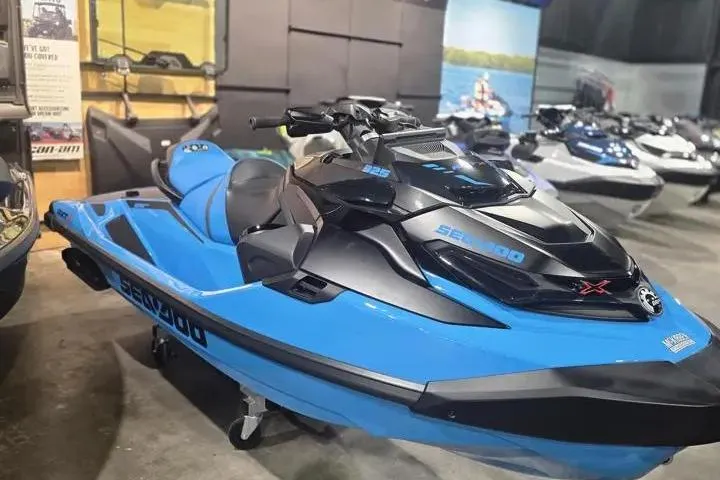 Slide: The Image of 2026 Sea-Doo RXT-X 325 jet ski in showroom, featuring sleek blue and black design. - 12