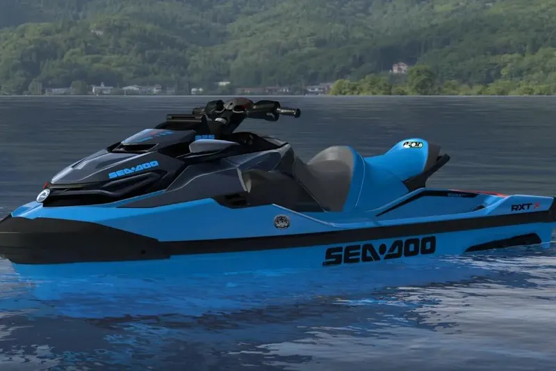 Slide: The Image of 2026 Sea-Doo RXT-X 325 jet ski on a serene lake with lush green hills. - 20