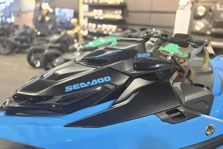 Slide: The Image of 2026 Sea-Doo RXT-X 325 jet ski in showroom, featuring sleek blue and black design. - 3