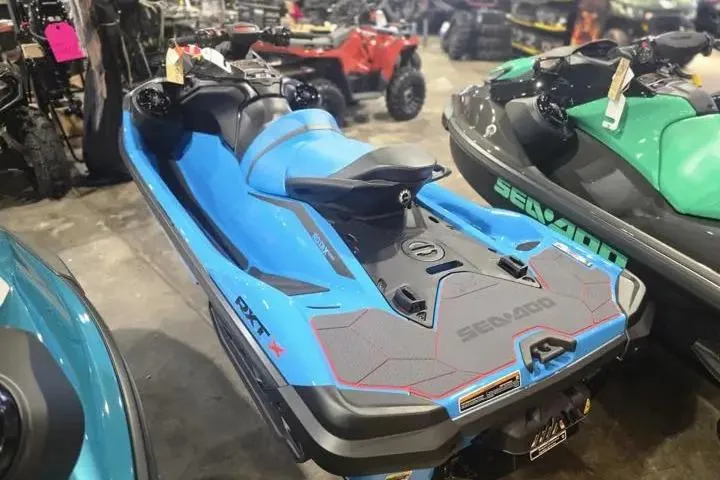 Slide: The Image of 2026 Sea-Doo RXT-X 325 in blue, displayed in a showroom with other watercraft. - 6