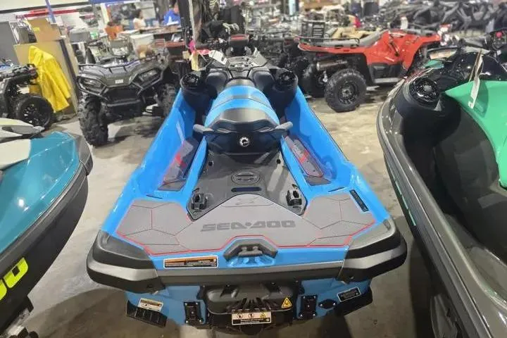 The Image of 2026 Sea-Doo RXT-X 325 jet ski in showroom, surrounded by other vehicles. - 7