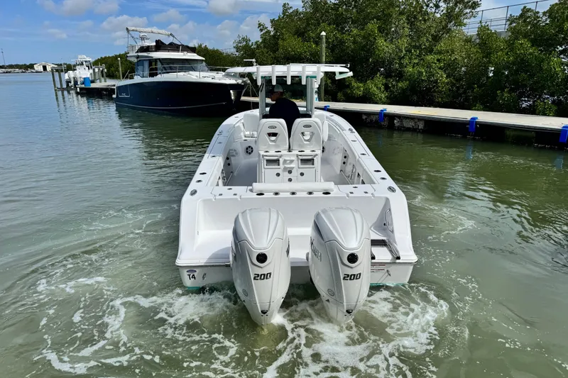 Slide: The Image of 2024 Sportsman Open 262 Center Console boat with dual engines in a marina. - 11