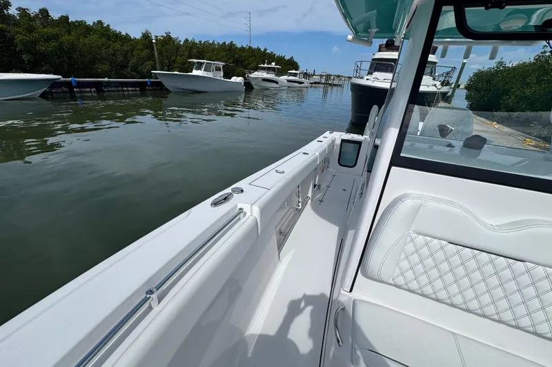 Slide: The Image of 2024 Sportsman Open 262 Center Console boat docked in a marina, surrounded by other vessels. - 14