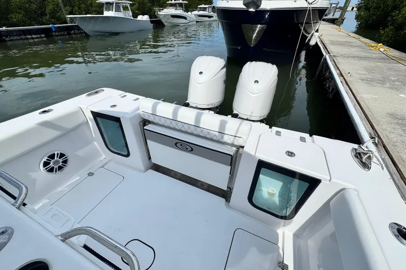 Slide: The Image of 2024 Sportsman Open 262 Center Console boat docked, featuring dual outboard engines. - 20
