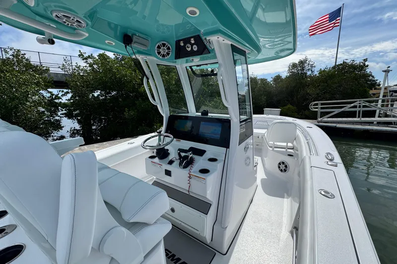 Slide: The Image of 2024 Sportsman Open 262 Center Console boat interior with helm, seating, and American flag. - 22