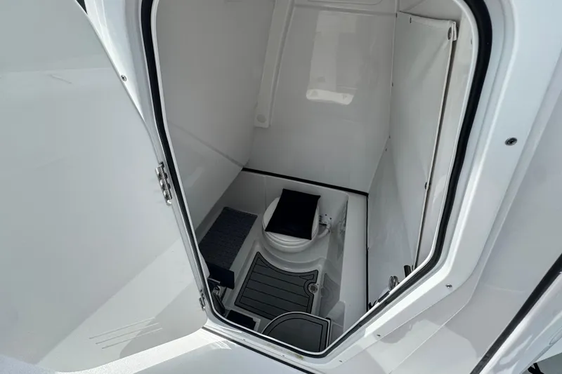 Slide: The Image of 2024 Sportsman Open 262 Center Console boat interior with compact marine toilet. - 23
