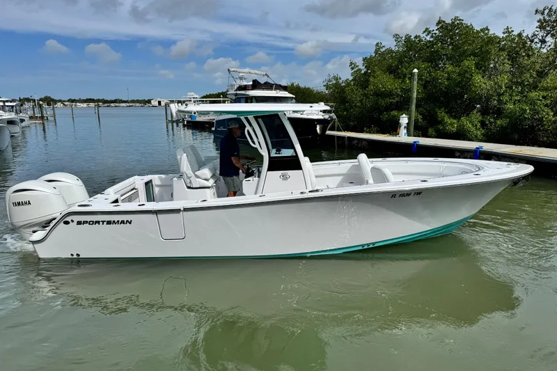 Slide: The Image of 2024 Sportsman Open 262 Center Console boat on calm water near a dock. - 5