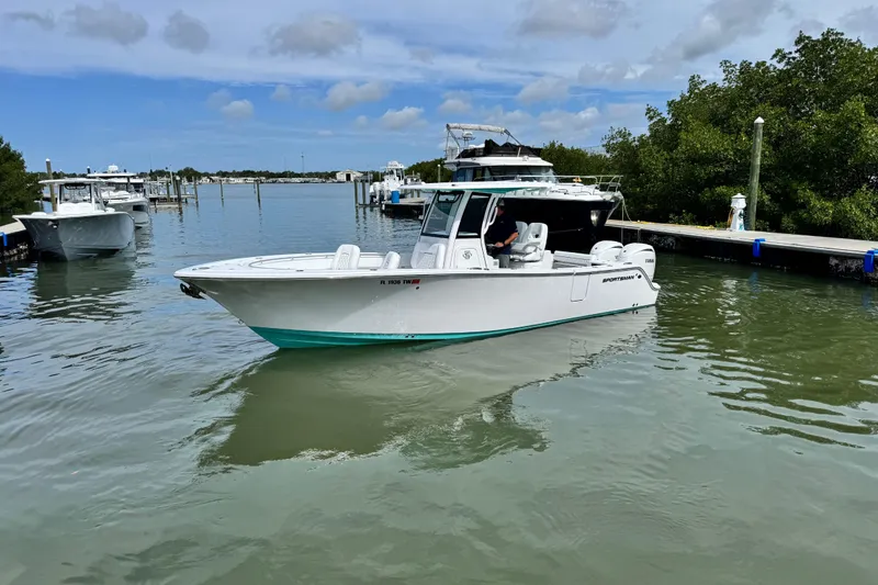 Slide: The Image of 2024 Sportsman Open 262 Center Console boat docked in a serene marina setting. - 6