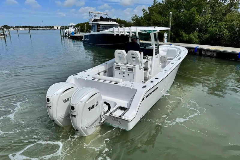 Slide: The Image of 2024 Sportsman Open 262 Center Console boat with twin Yamaha engines on calm water. - 7