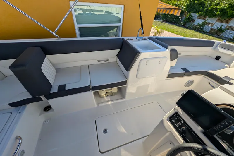 Slide: The Image of 2022 Bayliner DX 2000 boat interior with seating, sink, and control panel. - 5