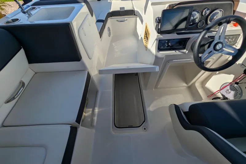 Slide: The Image of 2022 Bayliner DX 2000 boat interior with steering wheel, seating, and storage compartments. - 6