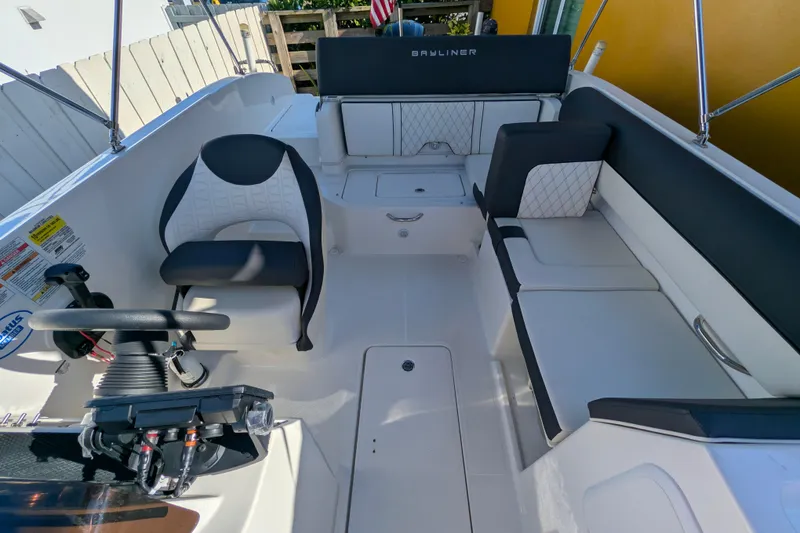 Slide: The Image of 2022 Bayliner DX 2000 boat interior with seating and steering console. - 7