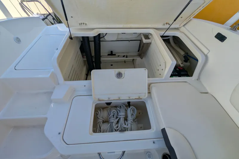 Slide: The Image of 2022 Bayliner DX 2000 boat storage compartments with ropes and equipment. - 9