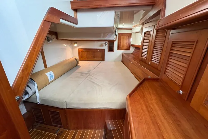 Slide: The Image of Interior of 2016 Gozzard 41 RC yacht, featuring wooden cabinetry and a cozy sleeping area. - 16
