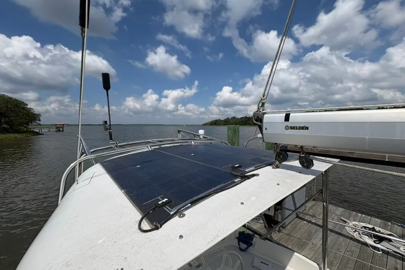Slide: The Image of Sailboat Gozzard 41 RC (2016) with solar panels on deck, docked by a scenic lake. - 41
