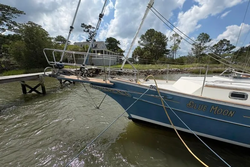Slide: The Image of Sailboat "Blue Moon" docked, Gozzard 41 RC, 2016 model, in a serene waterside setting. - 4